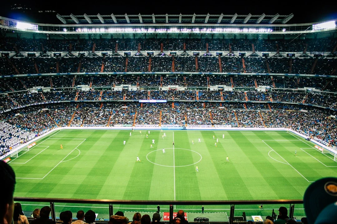 A floodlit soccer stadium viewed from the stands during a match
