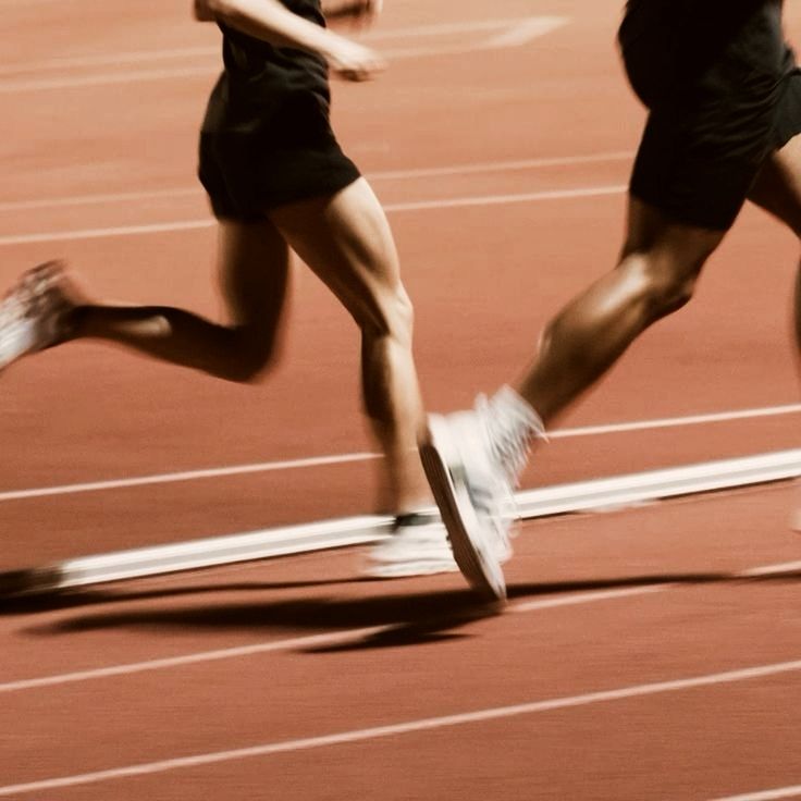 Two athletes running together on a track