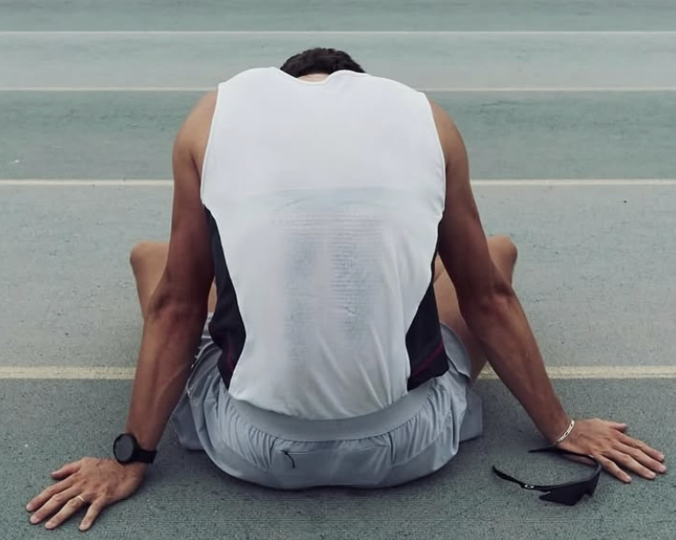 An athlete sitting quietly beside the track