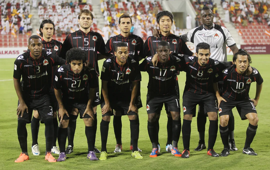 Al Rayyan football players posing together on the field before a match