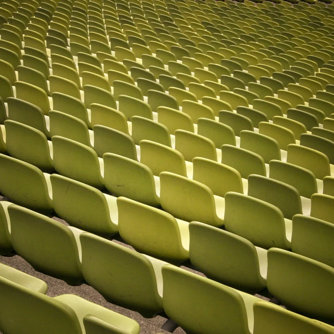Rows of empty stadium seats under evening light